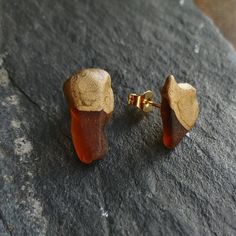 I have made these sea glass earrings of amber coloured sea glass pieces that I have found on the stunning coast of Scotland. To give them a modern, contemporary look, I have put a layer of gold enamel paint onto the top part of the earrings. I have attached the sea glass pieces onto 22k gold plated posts. These classy earrings have a nice drop because I have mounted the posts higher onto the glass piece. That means that the clear bottom part of the sea glass earrings is see-trough and remains li Classy Earrings, Sea Glass Earrings, Gold Stud Earrings, Enamel Paint, Earrings Minimalist, Amber Color, Clear Bags, Gold Stud, Gold Enamel