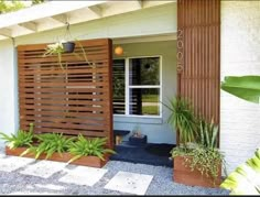 a house with wooden slats and plants in the front yard