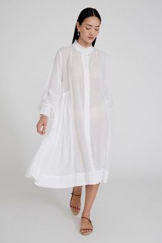 Cotton and viscose blend button down dress with ruffled details and balloon sleeves. 55% Cotton, 45% Viscose. 22.5" Bust, 23" Sleeve, 54.5" Bottom Width, 51" Total Length. One size: Fits sizes S-L. Machine wash cold. Made in India. Elegant Puff Sleeve Button-up Dress For Spring, Elegant Button-up Puff Sleeve Dress For Spring, Elegant Spring Puff Sleeve Button-up Dress, Elegant Button-up Puff Sleeve Dress For Work, Elegant Puff Sleeve Dress With Button Cuffs For Spring, Elegant Spring Puff Sleeve Dress With Button Cuffs, Chic Spring Midi Dress With Covered Buttons, Elegant Puff Sleeve Dress With Buttons For Daywear, Elegant Puff Sleeve Dress For Daywear With Buttons