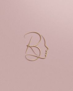 a woman's face is shown with the letter b in gold on a pink background