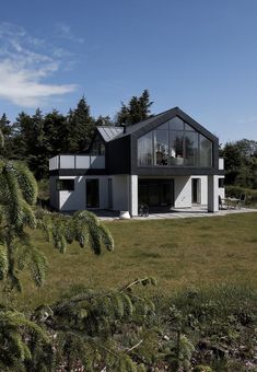 a large house sitting on top of a lush green field next to trees and grass