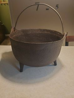 an old iron pot sitting on top of a counter