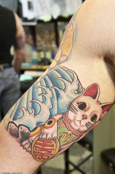 a man with a cat tattoo on his arm