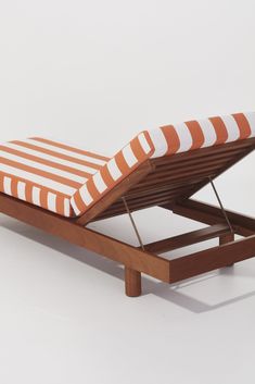 an orange and white striped chaise lounger with wooden legs on a white background