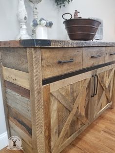 a kitchen island made out of wooden planks and metal handles, with a potted plant on top