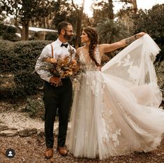 a bride and groom standing together in the woods