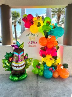 an arch decorated with balloons and flowers