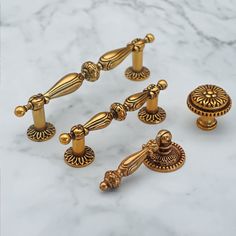 an assortment of golden handles and knobs on a marble surface