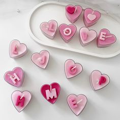 pink and white heart shaped magnets with the word love spelled out in large letters