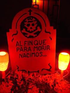 two lit candles sitting next to a sign that says al finque para moir nacimos