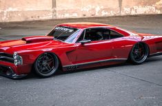 a red muscle car parked on the street