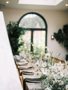 the table is set with white flowers and place settings for an elegant dinner party or special event