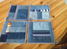 four pieces of blue fabric sitting on top of a wooden table covered in patchwork