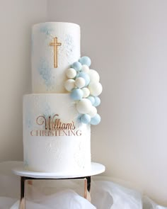 a wedding cake with blue and white frosting on the top is decorated with a cross