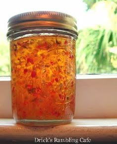 a jar filled with liquid sitting on top of a window sill