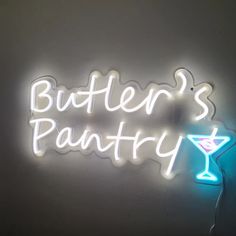 a neon sign that says butler's pantry with a martini in the foreground