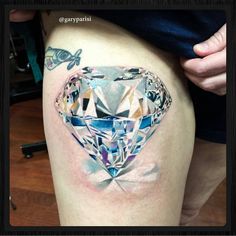 a woman's thigh with an artistic diamond tattoo on her left side ribcage