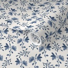 a blue and white floral wallpaper with leaves on the back, in an elegant pattern