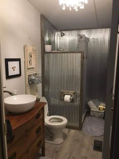 a bathroom with a toilet, sink and shower stall in the middle of the room