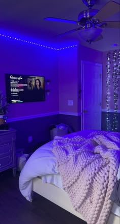 a bedroom with purple lighting and white bedding