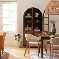 a dining room table with chairs and a hutch in the background