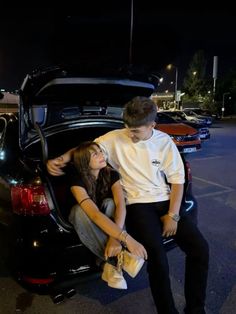 two people sitting in the trunk of a car