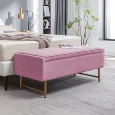 a bed with a pink footstool sitting on top of it