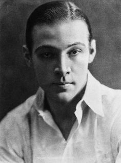 an old black and white photo of a young man with short hair wearing a collared shirt