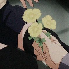 two people holding flowers in their hands while another person holds the other hand over them