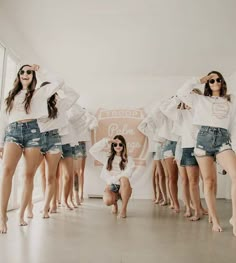 a group of young women standing next to each other in front of a white wall