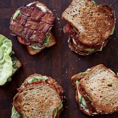 four sandwiches with lettuce and bacon on them