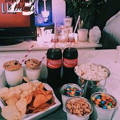 an assortment of snacks and drinks on a tray in front of a flat screen tv