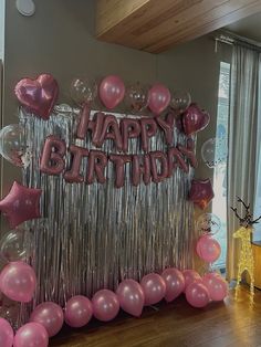 balloons and streamers decorate the entrance to a birthday party with pink and silver decorations