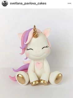 a small white and pink pony sitting on top of a table