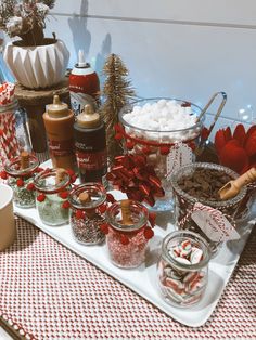 an assortment of candy and hot chocolates displayed on a serving platter with christmas decorations