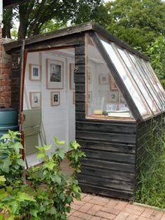 a small wooden shed with a glass roof