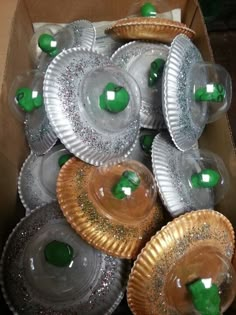 there are many plates in the box that have green decorations on them, and one is empty