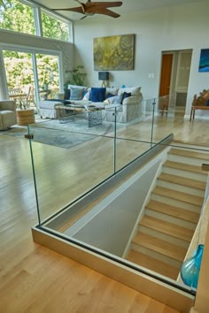 the inside of a house with wood floors and glass railings