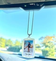 a photo hanging from a car's dashboard with a chain attached to the dash board