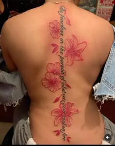 the back of a woman's body with pink flowers on it and an inscription that reads