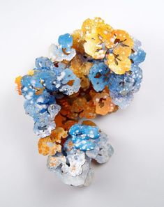 a cluster of blue and yellow flowers on a white surface