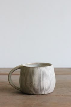 a white coffee cup sitting on top of a wooden table