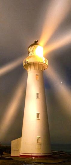 a light house is lit up at night