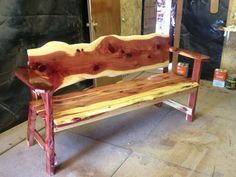 a wooden bench sitting on top of a floor next to a wall with wood planks