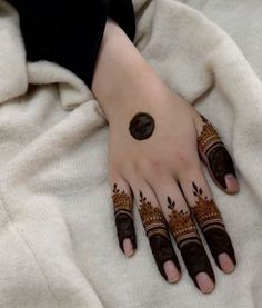 a woman's hand with henna tattoos on it