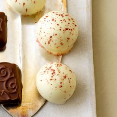 three chocolate covered desserts sitting on top of a table