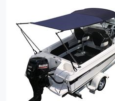 a white and black boat with a blue cover on it