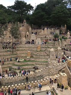 many people are walking around an old stone structure in the park, with stairs and steps leading up to it