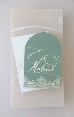 a green and white wedding card sitting on top of a table