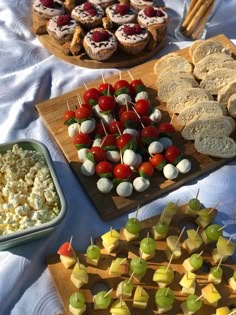 various snacks are displayed on wooden trays with white tablecloth and blue table cloth